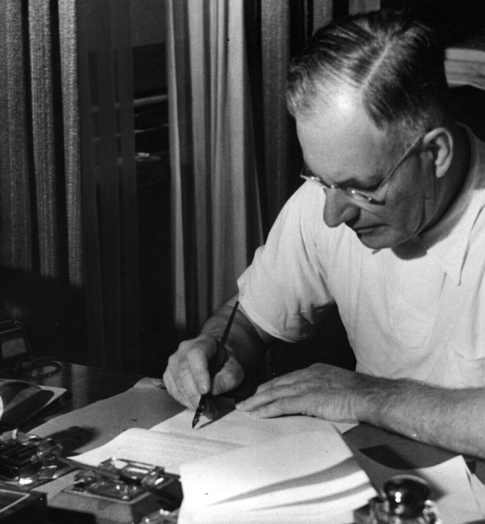 John Curtin writing at a desk