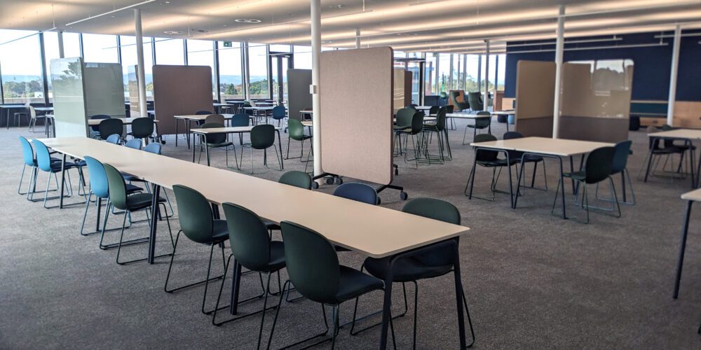 Level 7 study area with a long table, chairs and whiteboards.