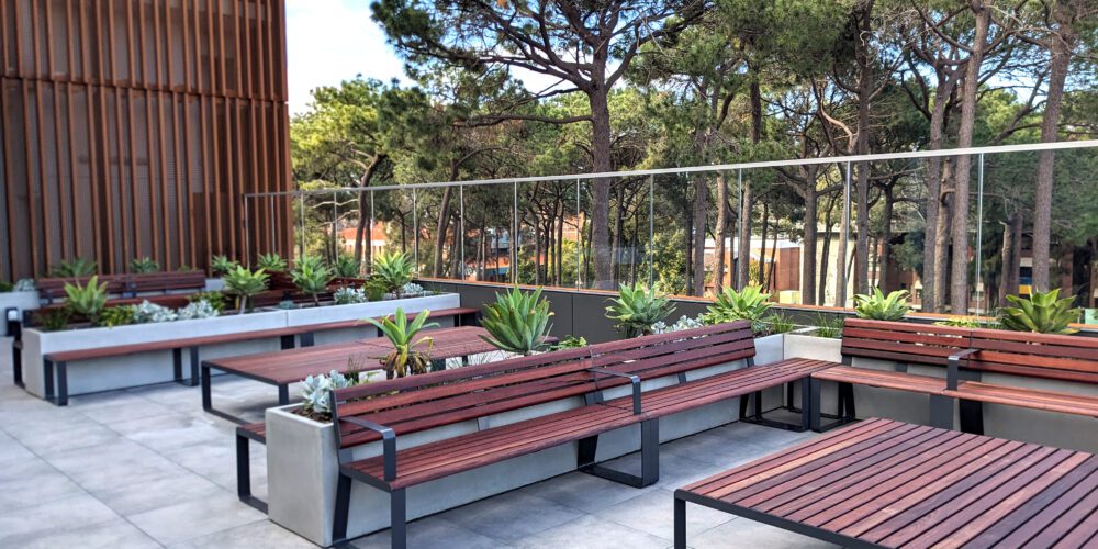 View of level 4 outdoor terrace. Wooden benches and tables, and plants are visible.